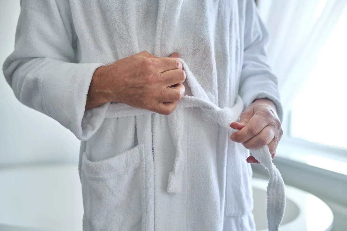 cropped-photo-male-standing-near-bathtub-while-tying-belt-his-towelling-robe